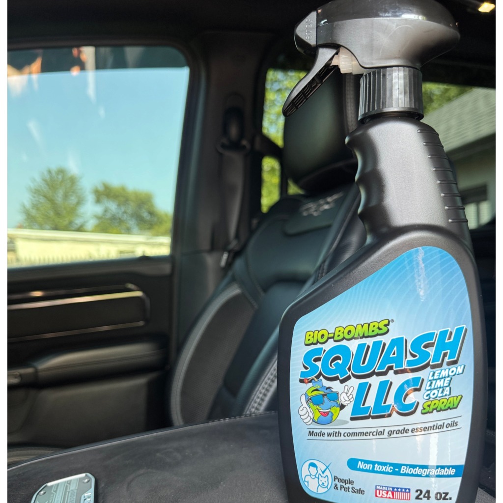 That Detail Shop Bio-Bombs Squash LLC air freshener spray bottle sitting on a car seat for a fresh interior finish.