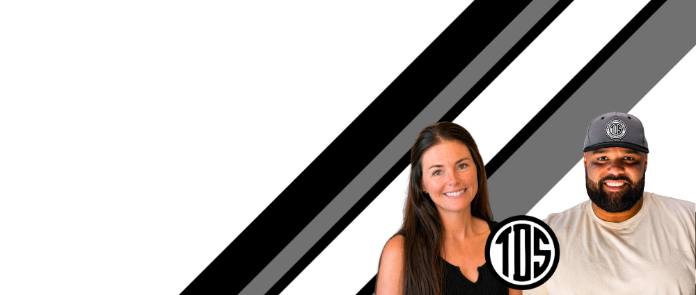 Two people standing against a black and white striped background with a logo in the corner.