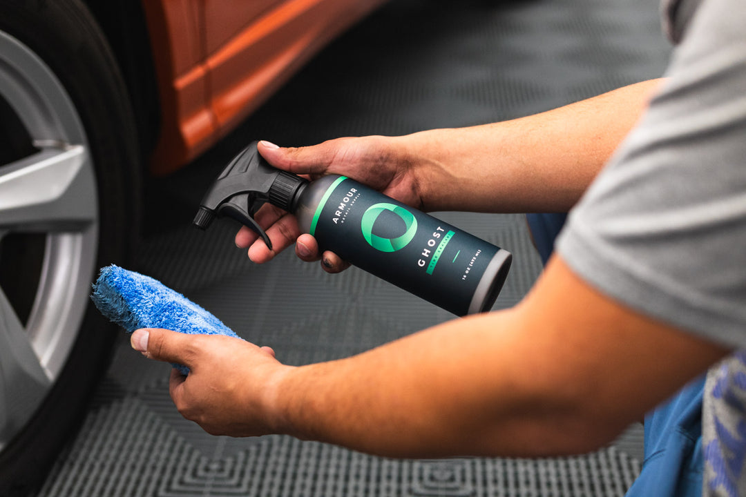 GHOST Tire Sealant being sprayed onto a blue tire applicator beside a wheel.