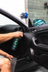 PILOT Interior Detailer being sprayed onto a vehicle's interior door panel.