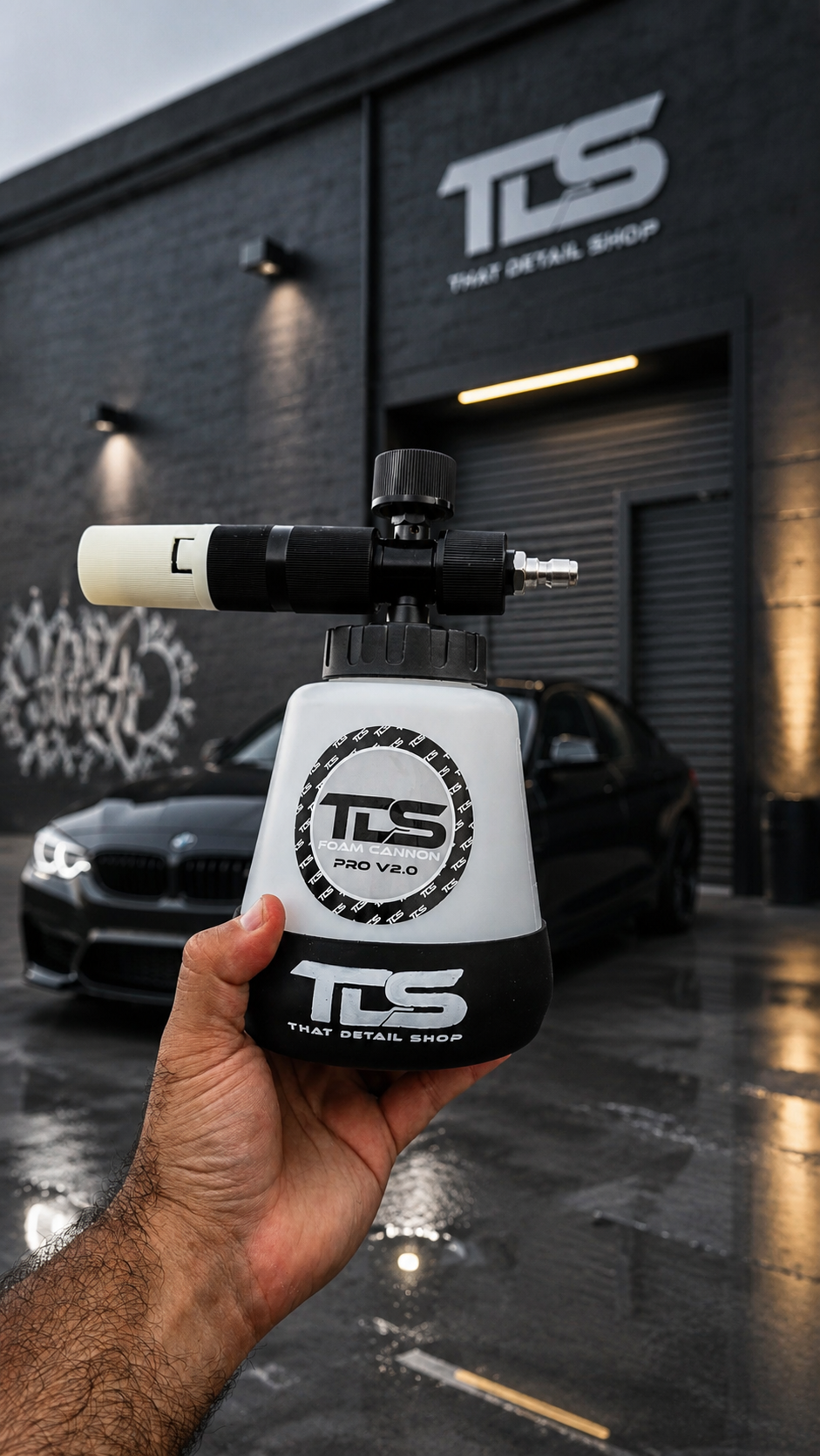 Hand holding a TDS detailing tool in front of a building with TDS branding.