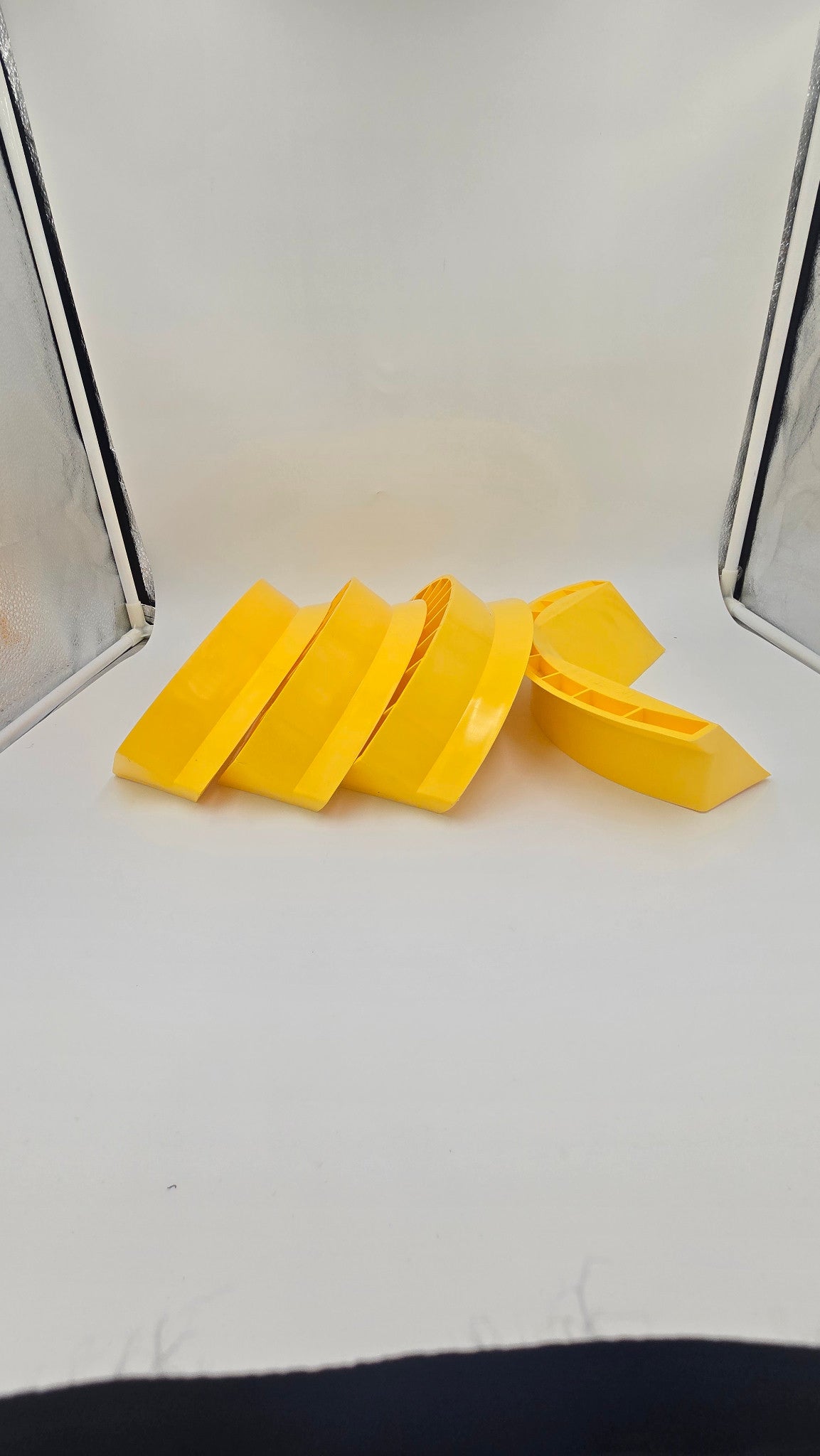 Four yellow Hozeez hose guides shown from a side angle