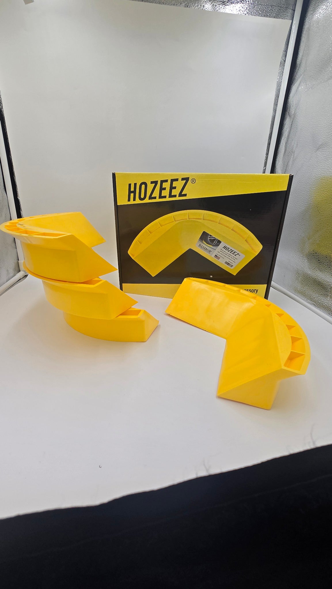 Four yellow Hozeez car wash hose guides displayed with Hozeez-branded packaging