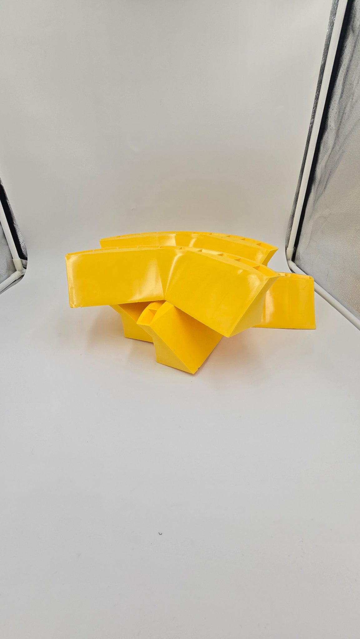 Yellow Hozeez car wash hose guides stacked to show their shape
