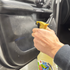 That Detail Shop Bio-Bomb Minis cleaning solution being sprayed onto a car door panel for odor treatment