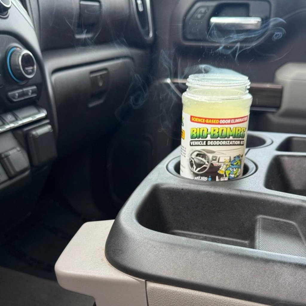 That Detail Shop Bio-Bombs vehicle deodorization kit activating in a car cup holder with visible vapor