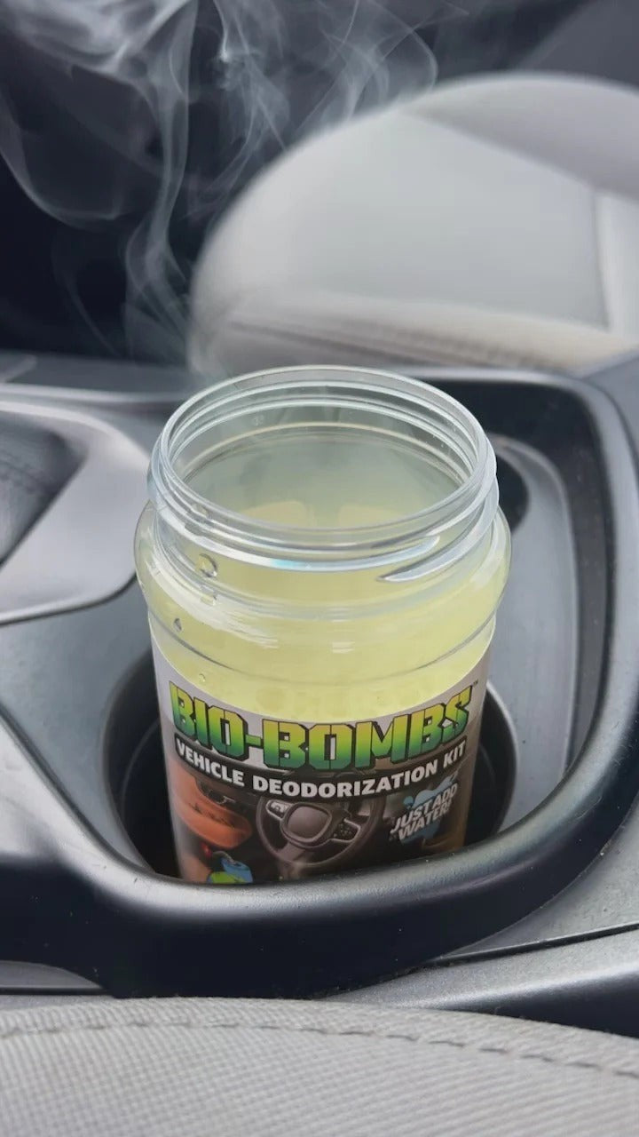 That Detail Shop Bio-Bombs Vehicle Deodorization Kit in a car cup holder, emitting a light mist.