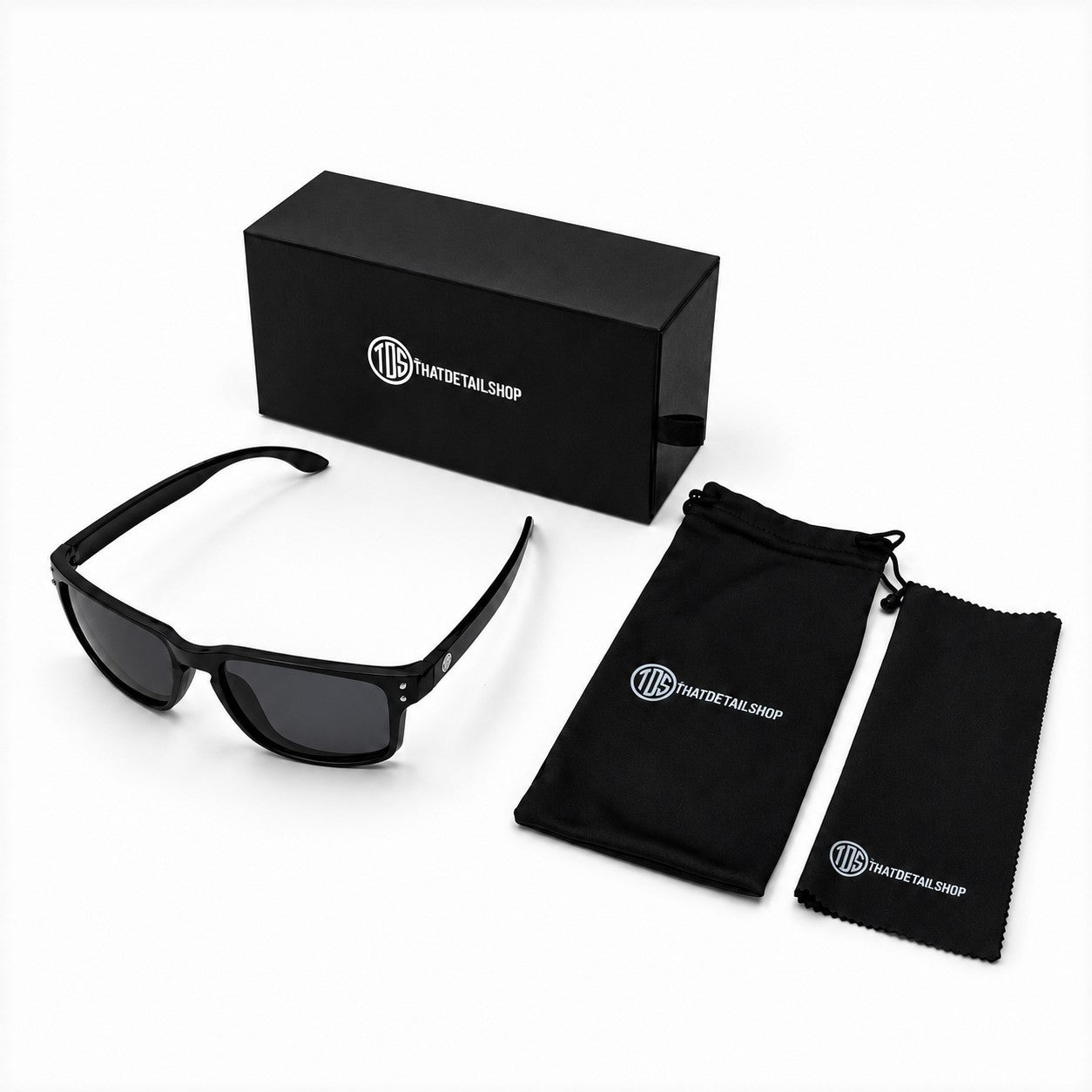 That Detail Shop polarized sunglasses in matte black with a branded box, soft storage bag, and lens cleaning cloth.