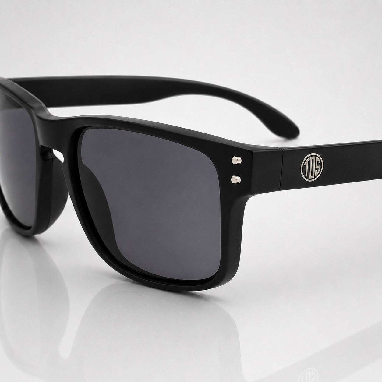 That Detail Shop matte black polarized sunglasses with a classic square frame and subtle TDS logo on the temple.