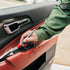 That Detail Shop detailing brush cleaning car door panel with red leather and black plastic trim.