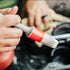 That Detail Shop detailing brush with white bristles and red ferrule cleaning car interior.
