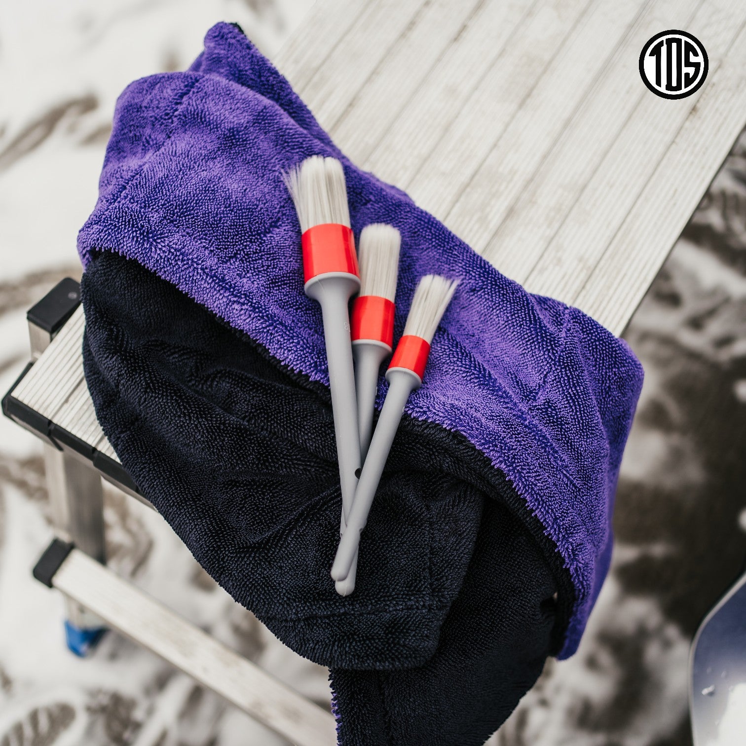 That Detail Shop detailing brushes set with ultra-soft bristles and red accents on purple and black microfiber towels.