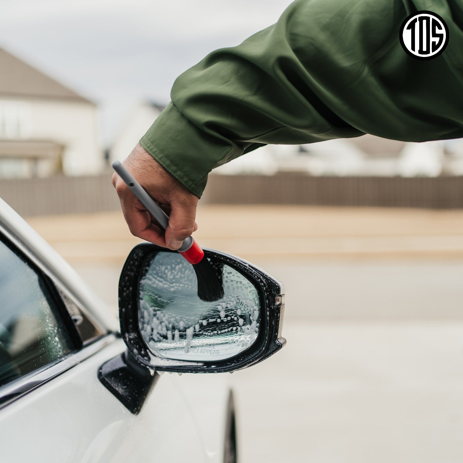 That Detail Shop exterior detailing brush cleaning a car's side mirror with foam.