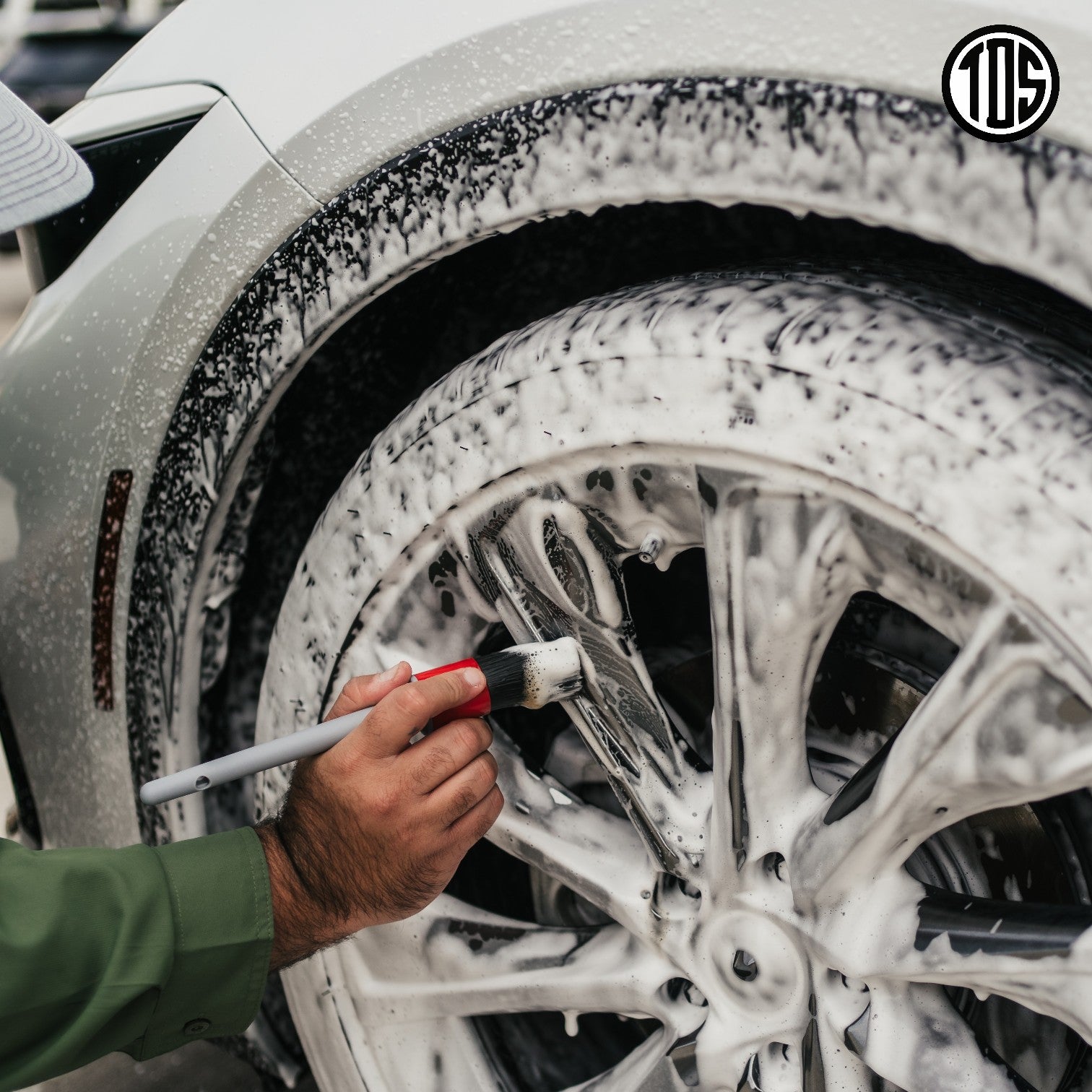 That Detail Shop exterior detailing brush cleaning a white car wheel covered in foam.
