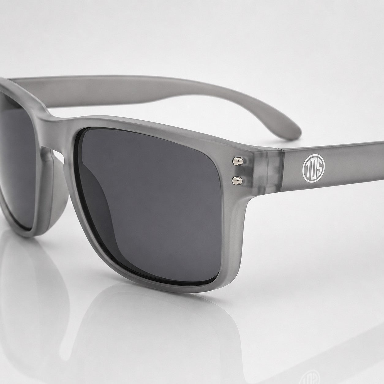 That Detail Shop Frost Gray polarized sunglasses with a square frame and subtle temple logo on a white background.