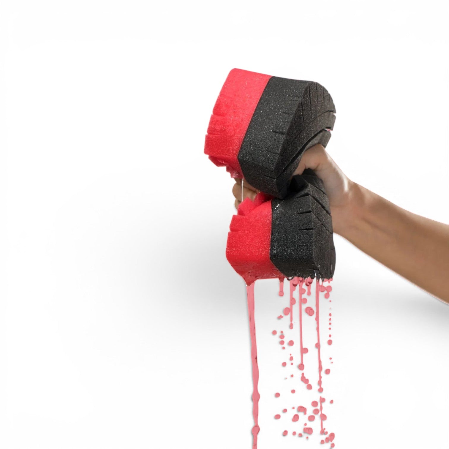 That Detail Shop Legacy Sponge, a large dual-tone red and black foam car wash sponge, being squeezed to release soapy water.