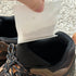 That Detail Shop Odor Control Granule Sachets being placed into a brown and black hiking boot.