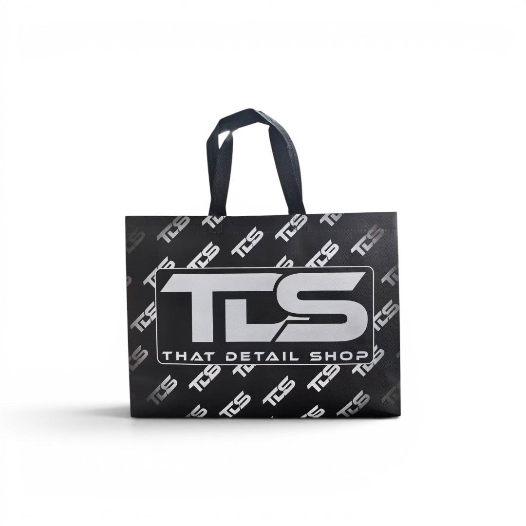 That Detail Shop reusable black tote bag featuring a bold white TDS logo and repeating pattern on a white background.