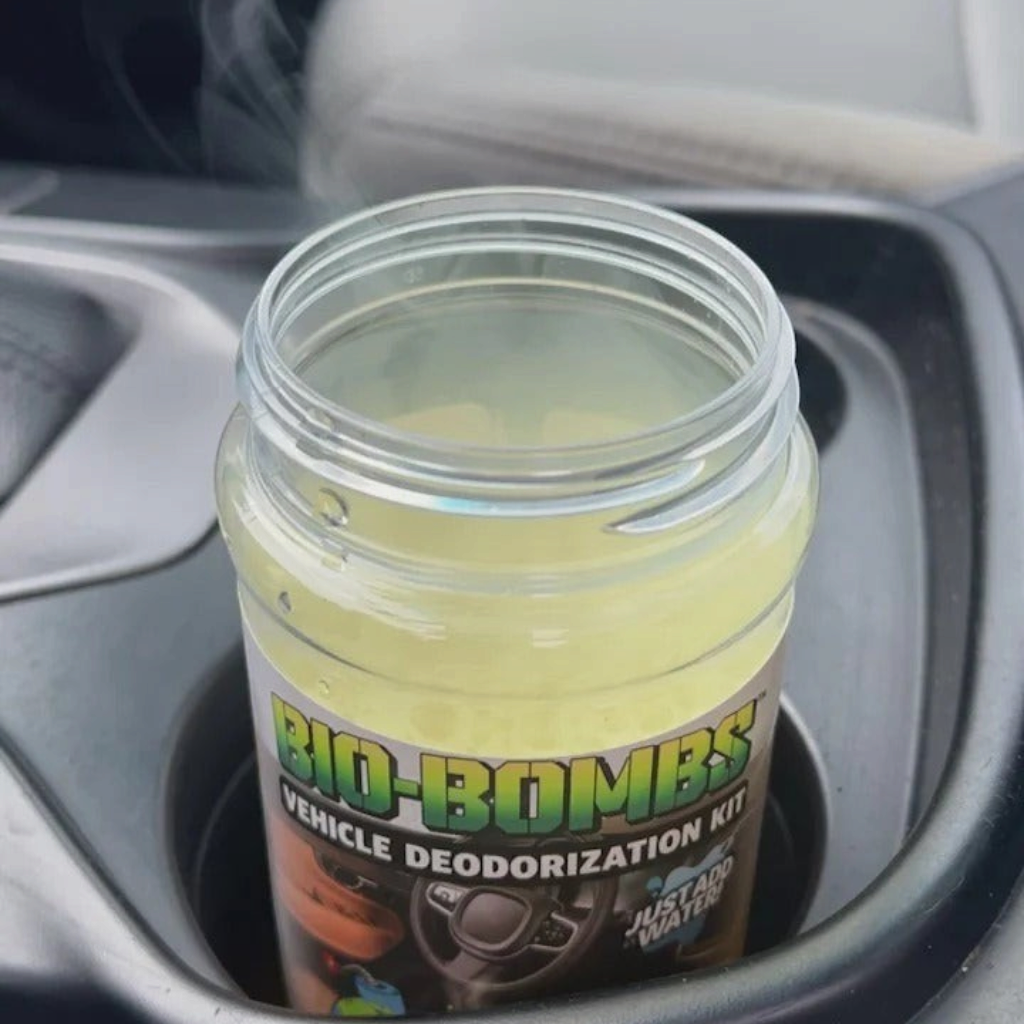 That Detail Shop Bio-Bombs vehicle deodorization kit activating in a car cup holder with visible vapor
