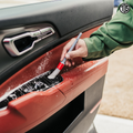 That Detail Shop interior detailing brush cleaning car door panel crevices and buttons with soft bristles and foam.