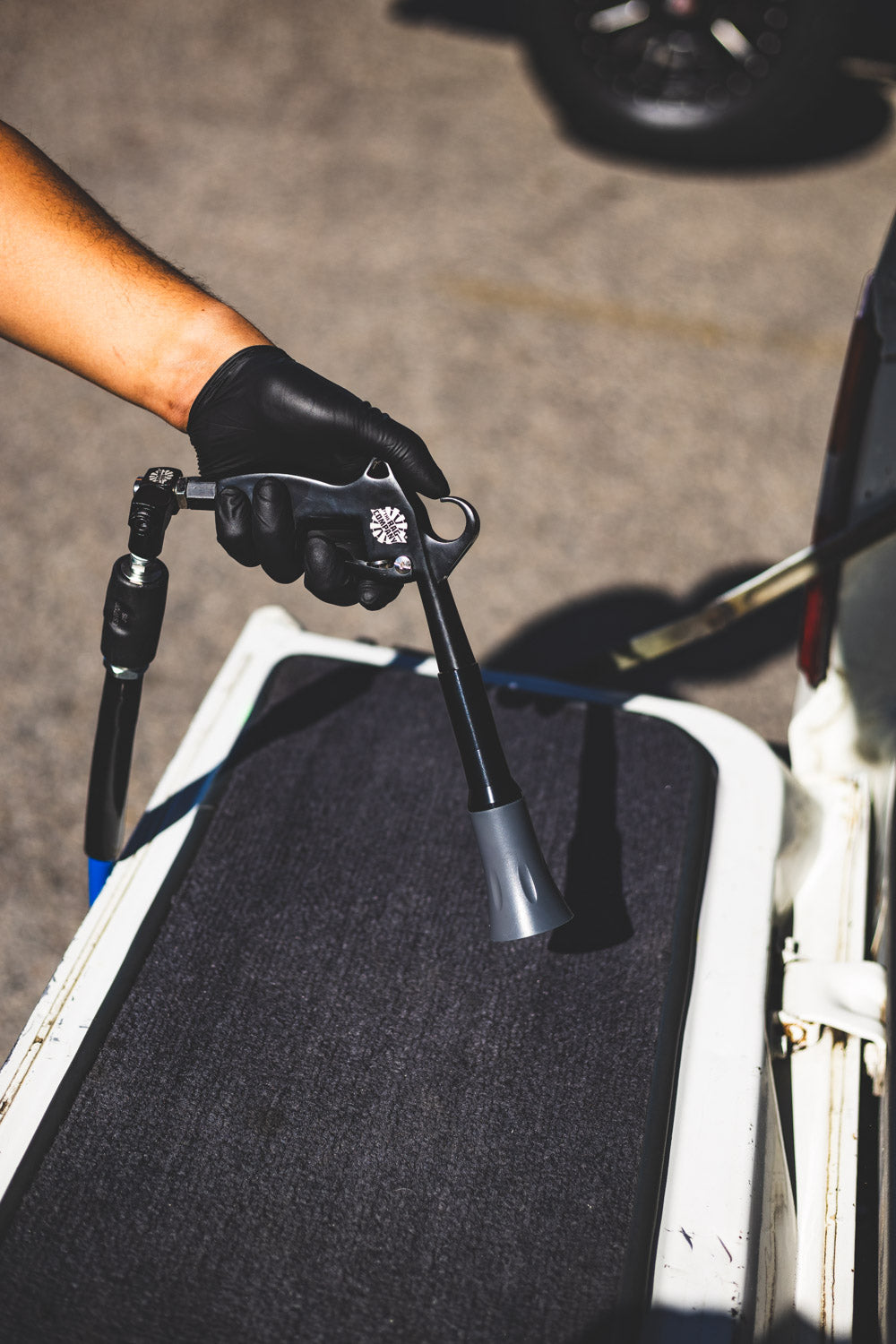 ULTRA Air Swivel in use with a compressed-air tool above a vehicle floor mat.